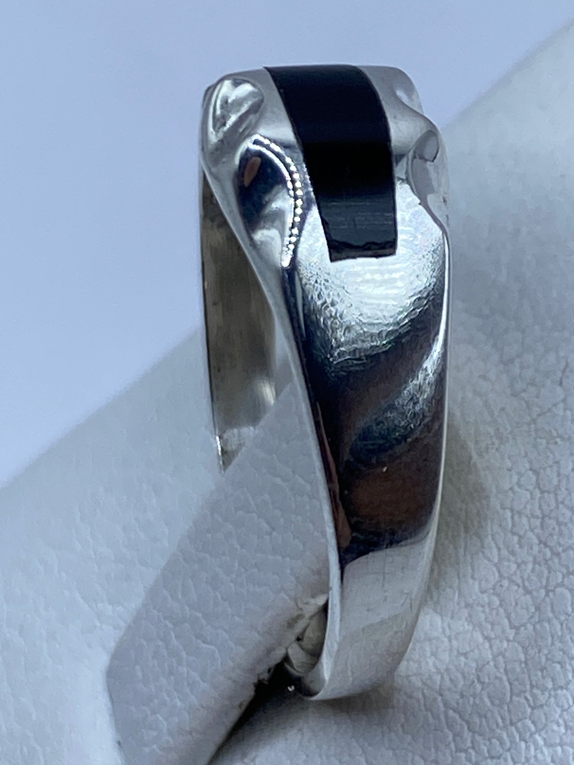 Anillo en la mano mostrando el tamaño y la proporción del ónix negro con la banda de plata