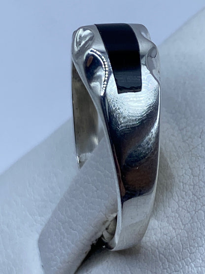 Anillo en la mano mostrando el tamaño y la proporción del ónix negro con la banda de plata