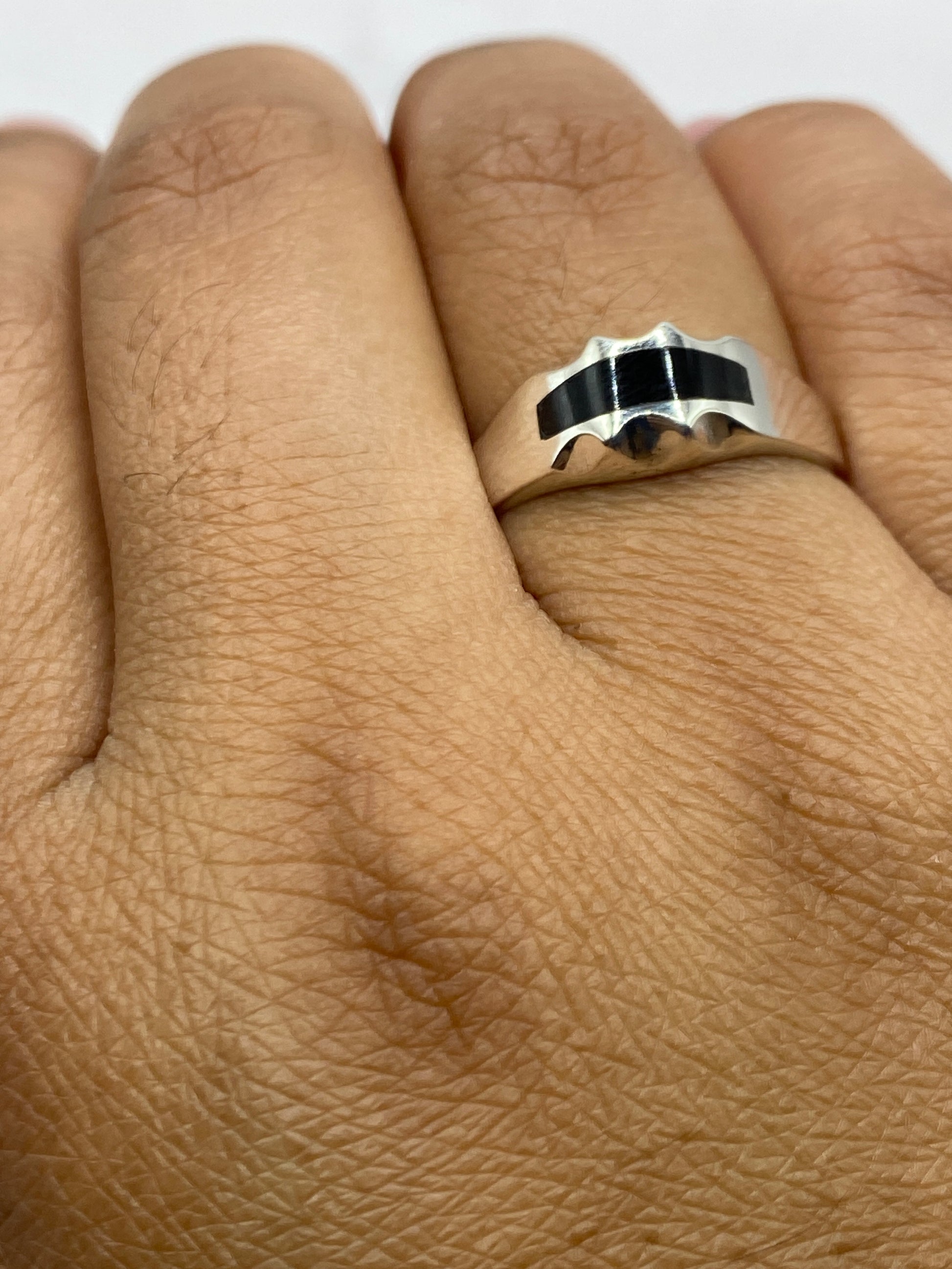 Vista lateral del anillo de plata con ónix, mostrando el sello 925 y el acabado pulido