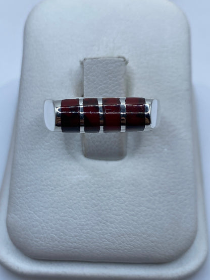 Anillo de plata .925 con coral rojo engastado en la mano de una mujer