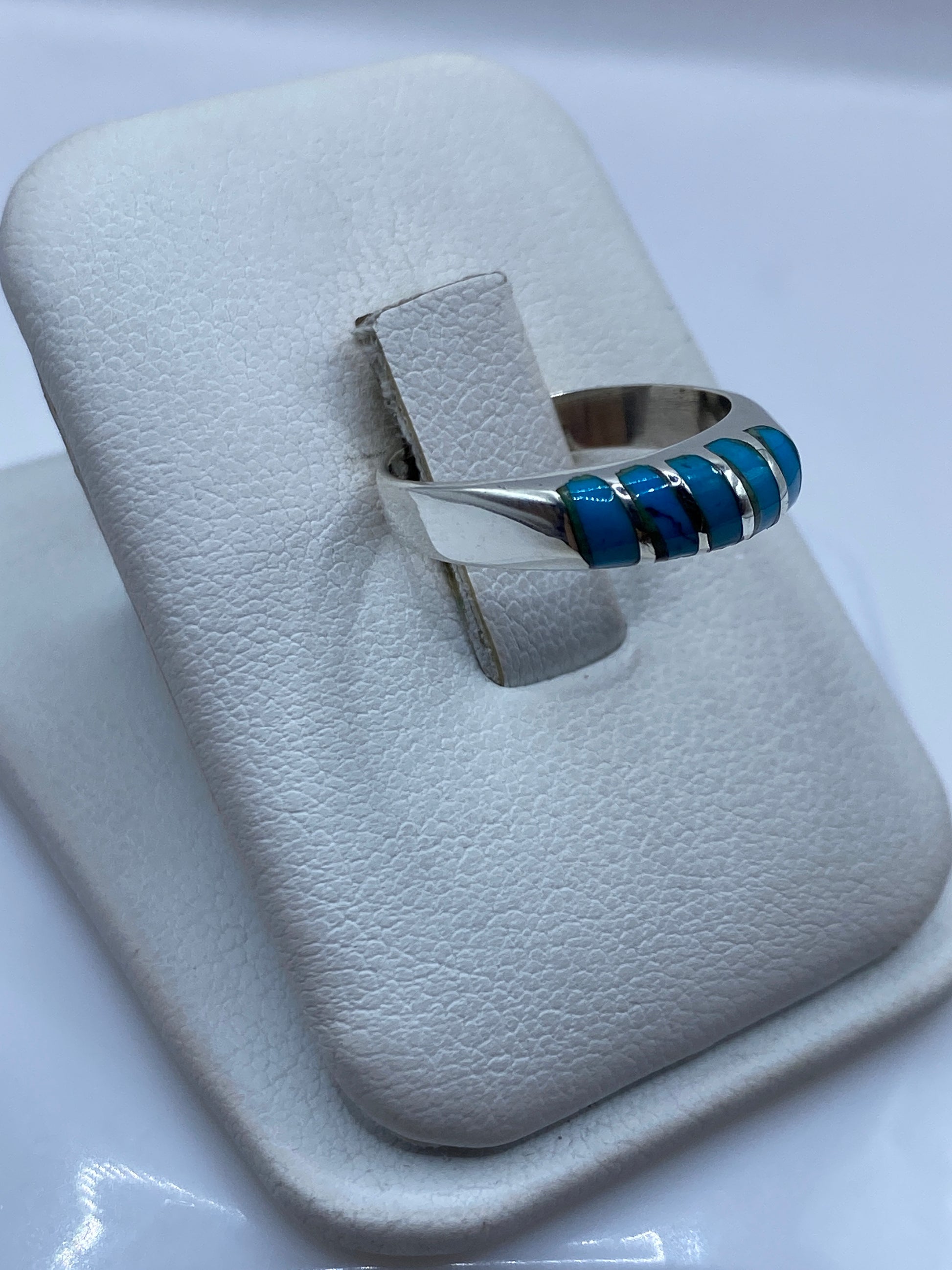Detalle frontal del anillo minimalista con piedra azul engastada