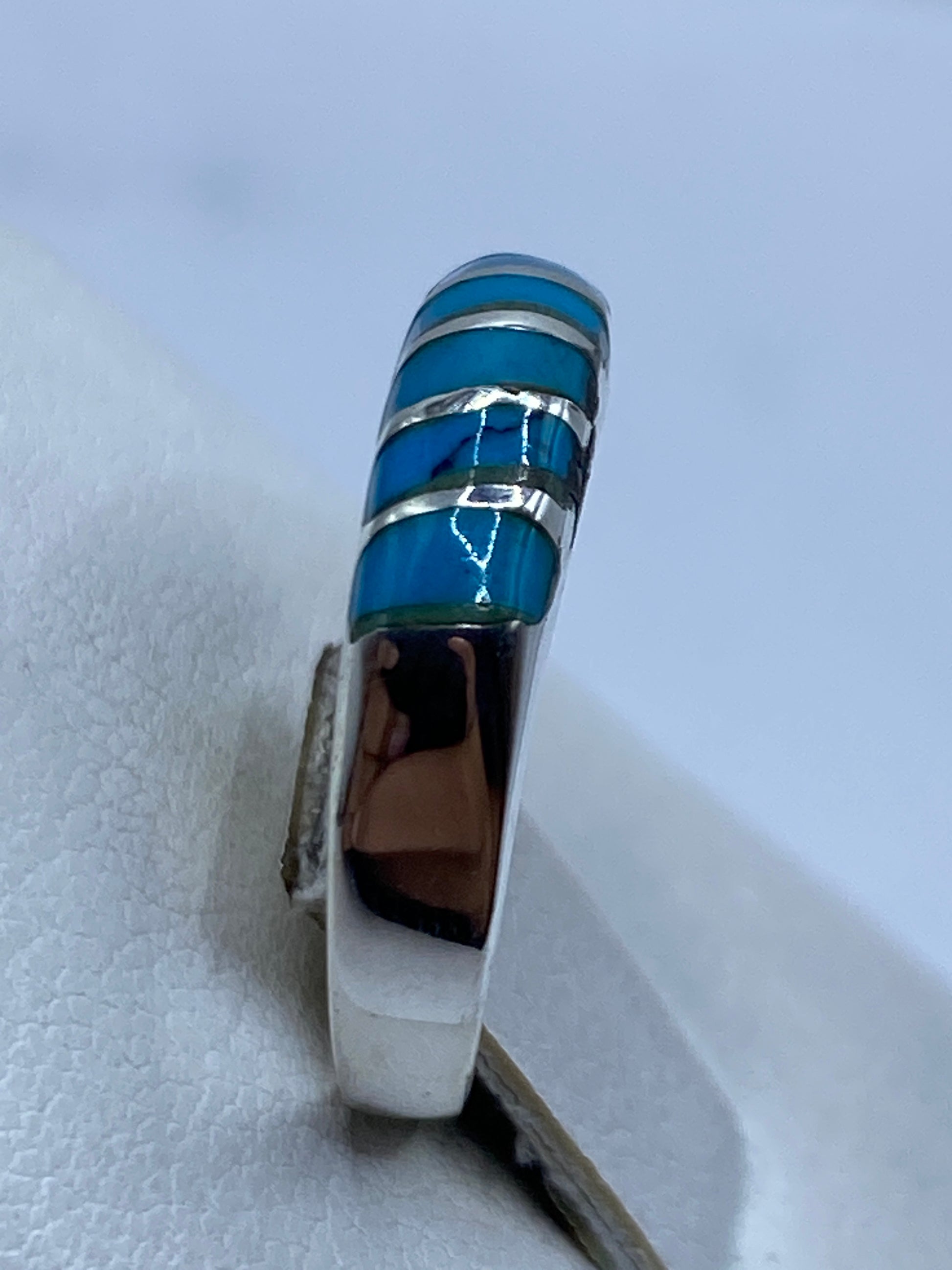 Anillo de plata azul en la mano mostrando el pulido limpio de la banda
