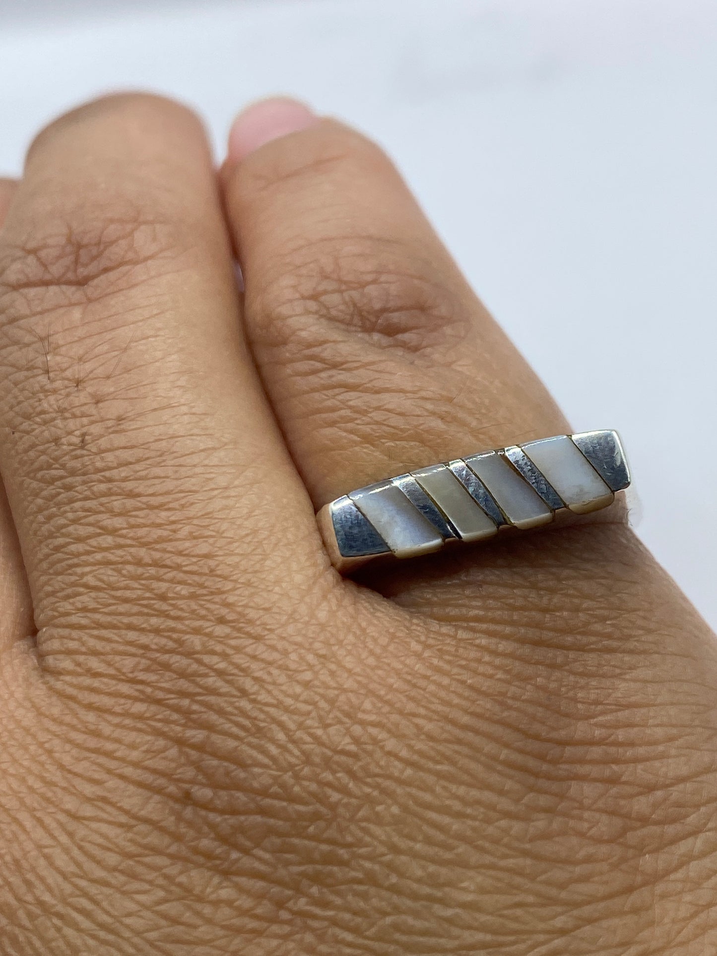 Anillo de plata sobre fondo blanco mostrando sello .925 auténtico