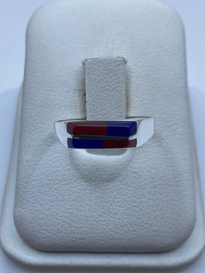 Anillo de plata solitario con piedra roja en la mano de una mujer