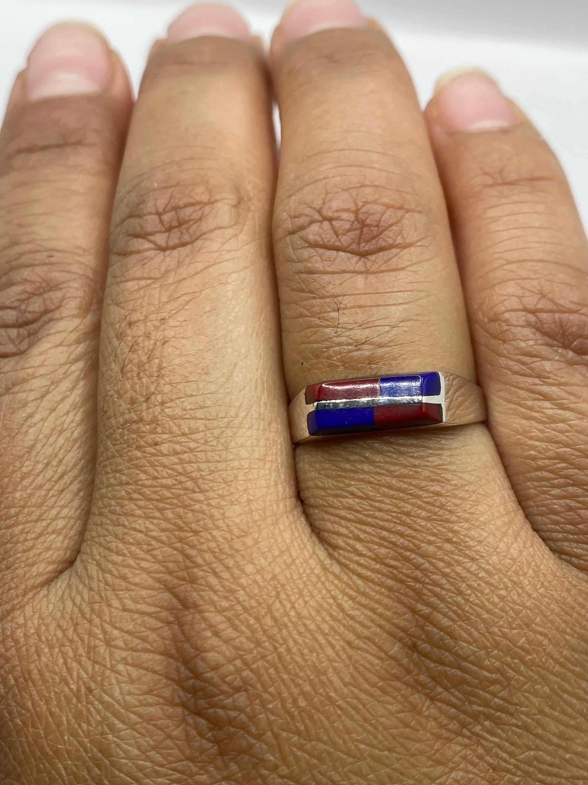 Anillo solitario sobre fondo blanco exhibiendo el sello .925 de Taxco