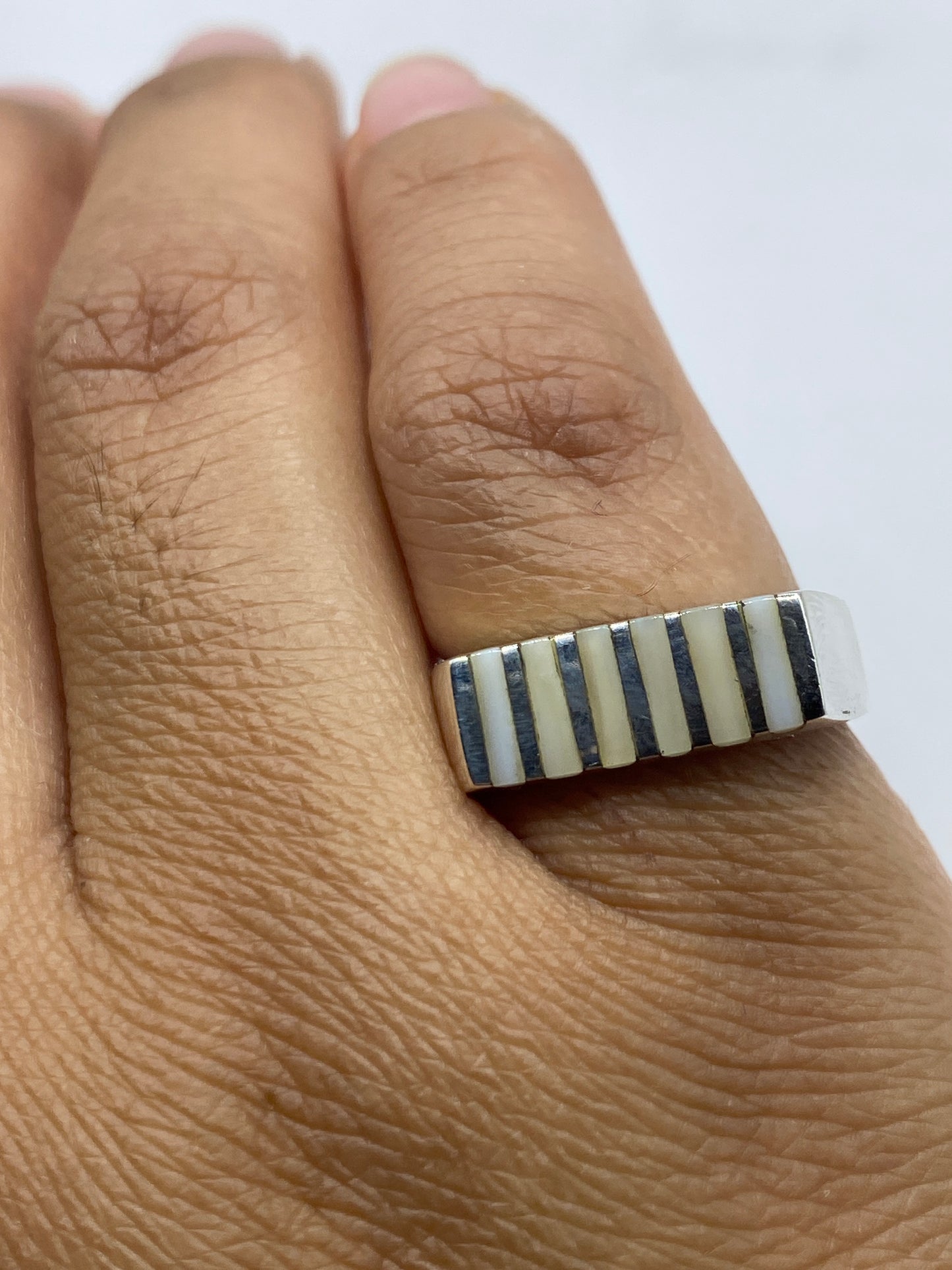 Anillo de perfil mostrando banda estructurada y sello 925
