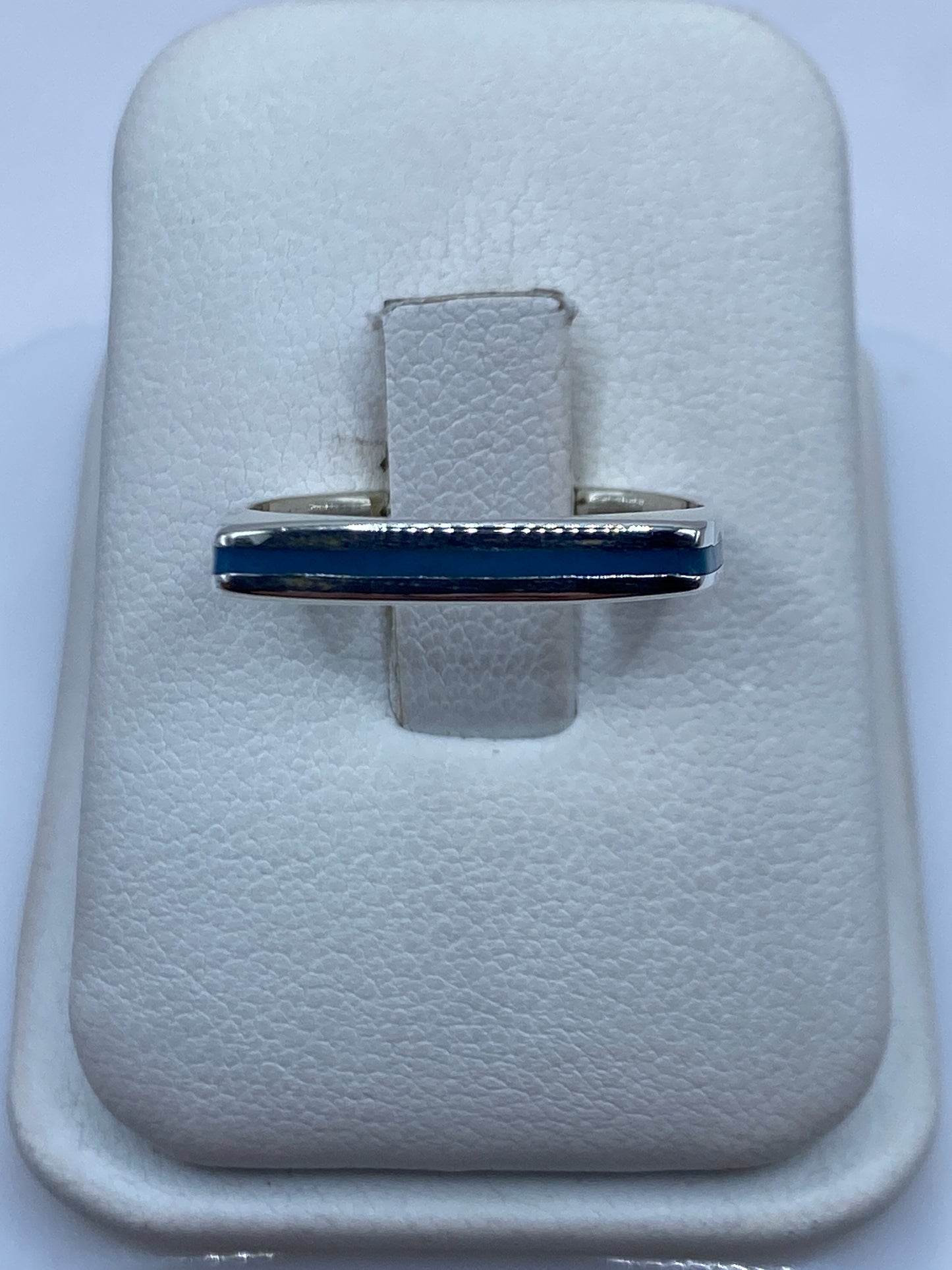 Anillo de plata banda minimalista con piedra azul cielo en la mano
