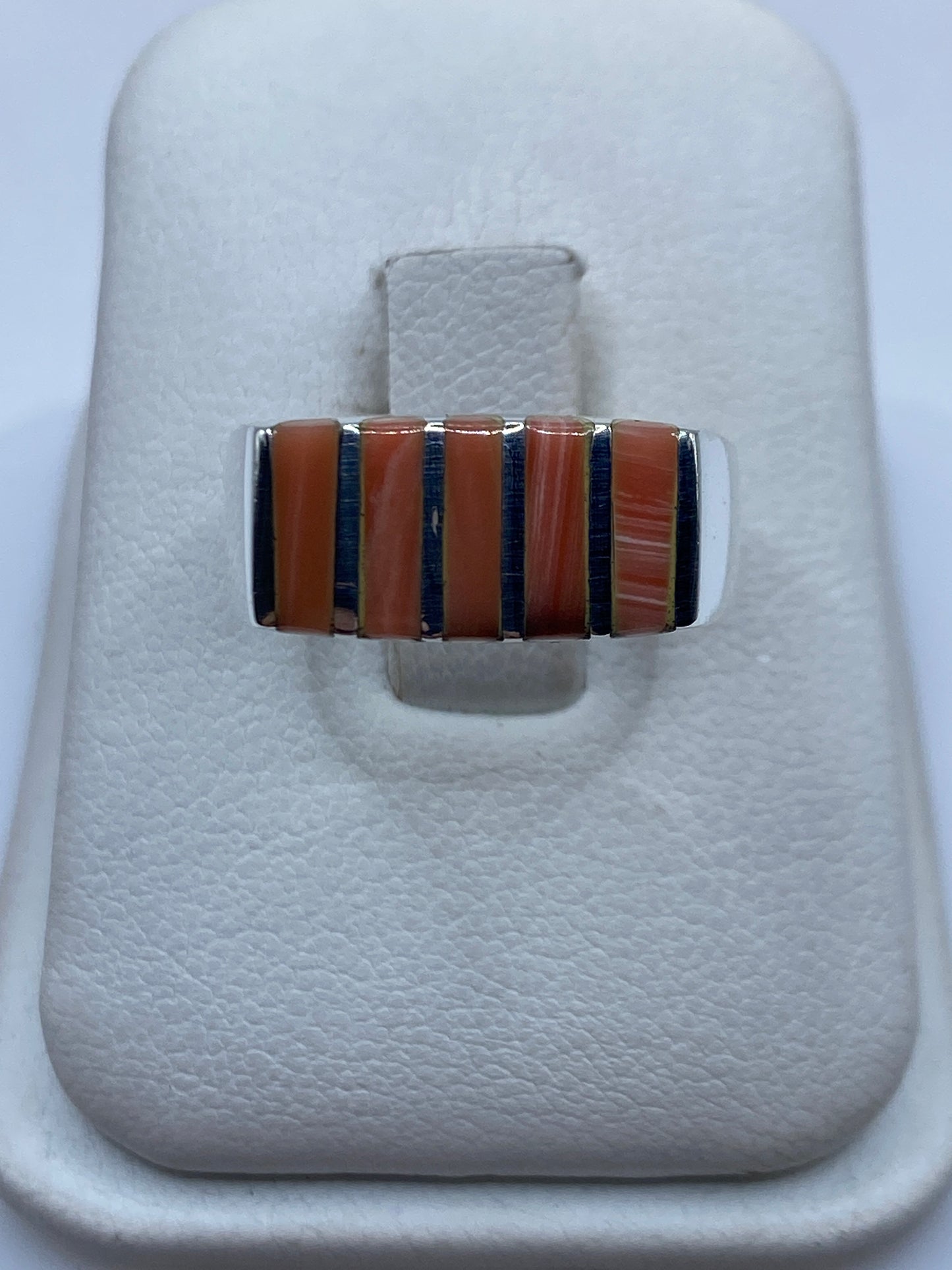 Anillo de plata .925 con diseño geométrico y piedra natural engastada, mostrado en joyero blanco