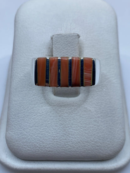 Anillo de plata .925 con diseño geométrico y piedra natural engastada, mostrado en joyero blanco