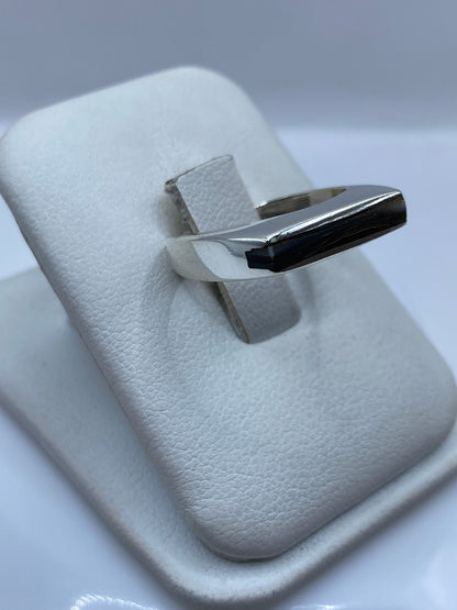 Vista lateral del anillo minimalista en plata pulida mostrando el engaste central