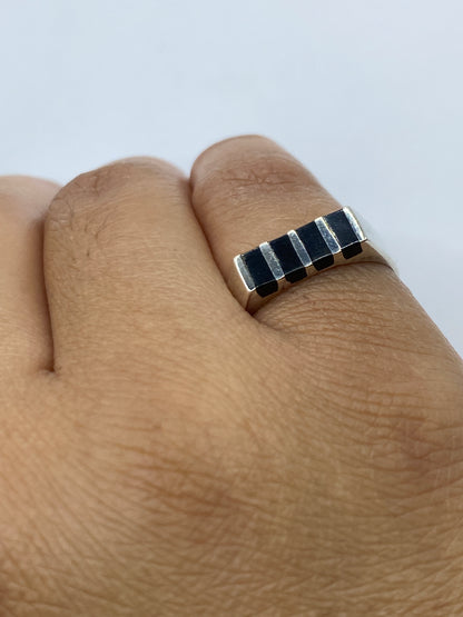 Anillo de plata con ónix puesto en dedo, mostrando el sello 925 MEXICO