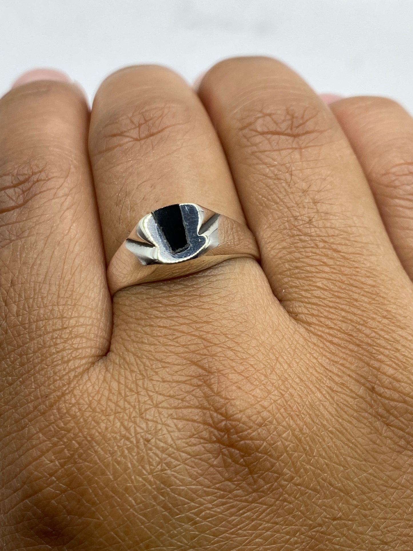 Anillo con ónix negro puesto en mano, mostrando proporción y presencia