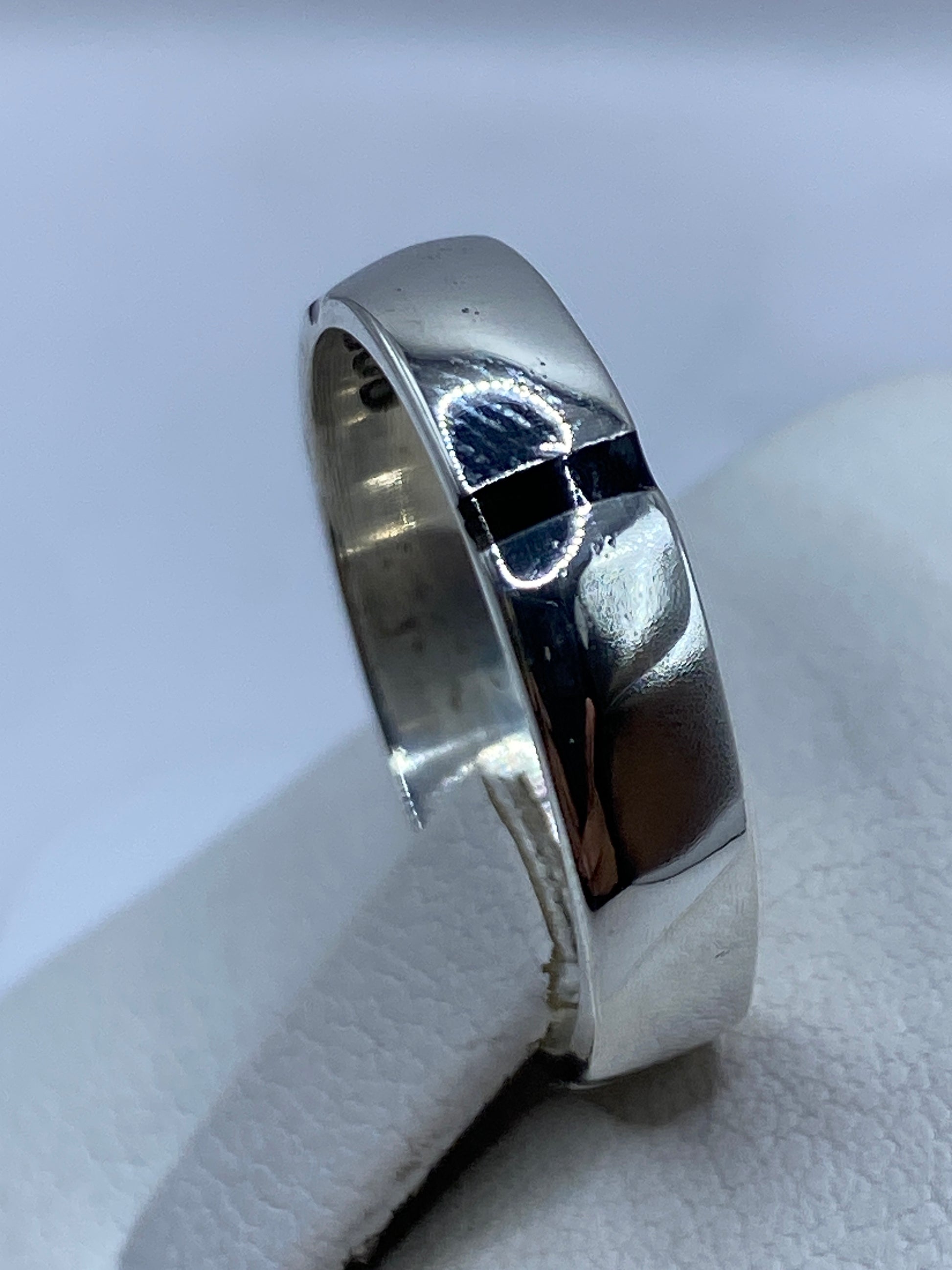 Anillo sello minimalista en mano, mostrando proporciones y color profundo