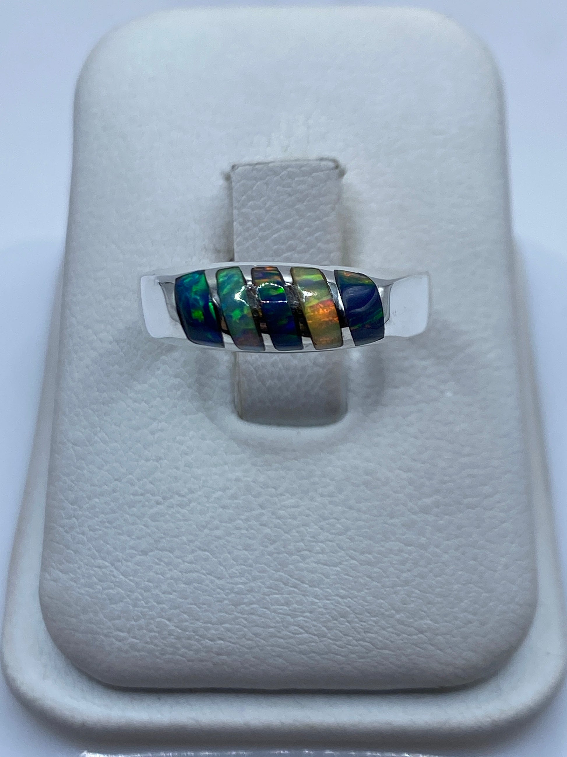 Anillo de plata con ópalo de fuego multicolor mostrando juego de verdes, azules y naranjas
