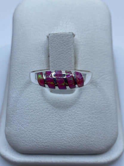 Anillo de plata con ópalo de fuego rosa mostrando colores únicos en cada ángulo