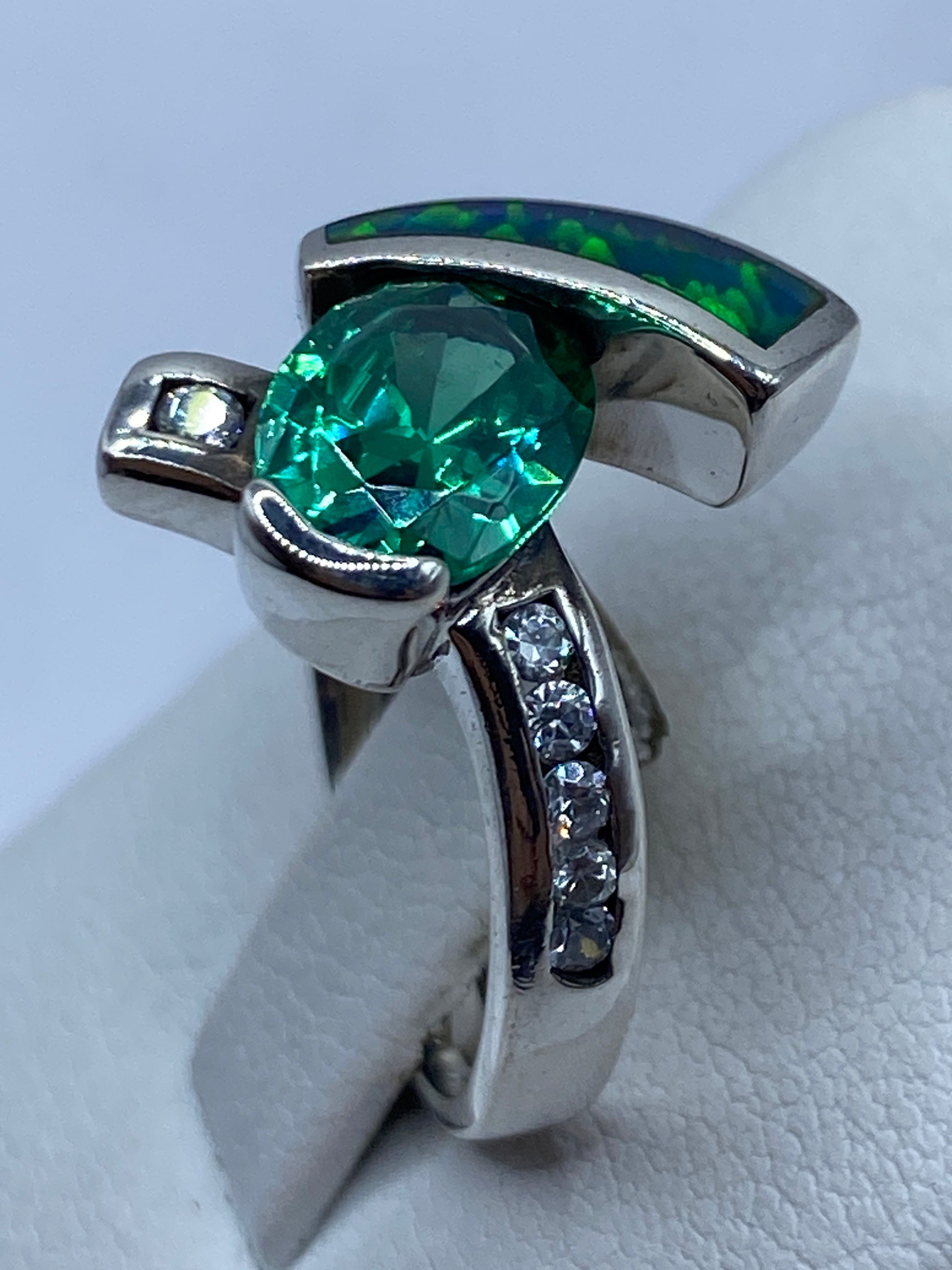 Anillo asimétrico sobre dedo mostrando el juego de colores natural del ópalo