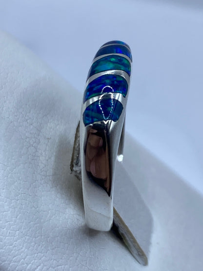 Ópalo de fuego azul en anillo de plata, mostrando juego de luz y color