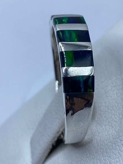 Detalle del ópalo de fuego con reflejos verdes y azules naturales montado en plata
