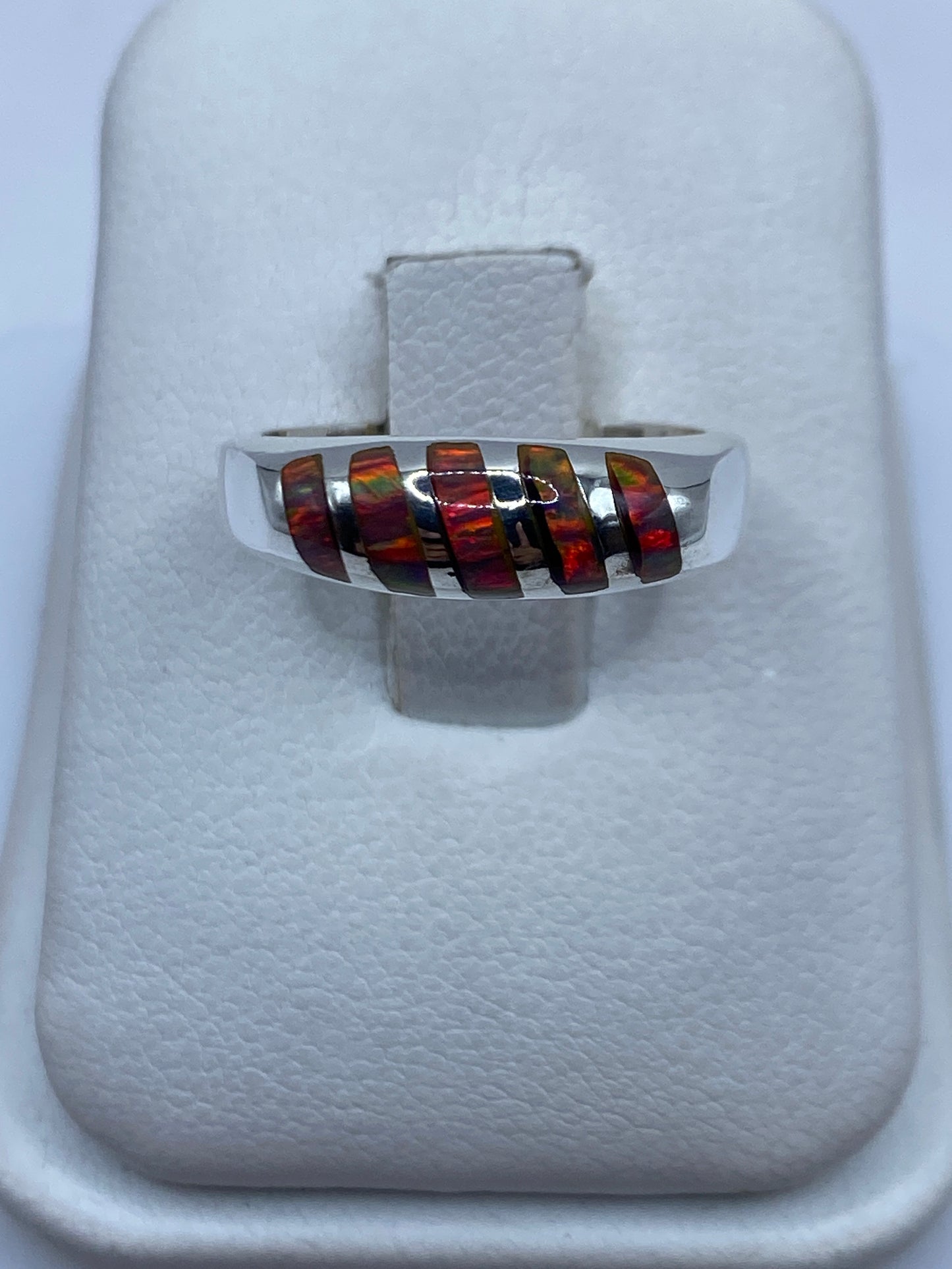 Anillo de plata .950 con ópalo de fuego multicolor en dedo de mujer, mostrando el juego de colores naranja y rojo