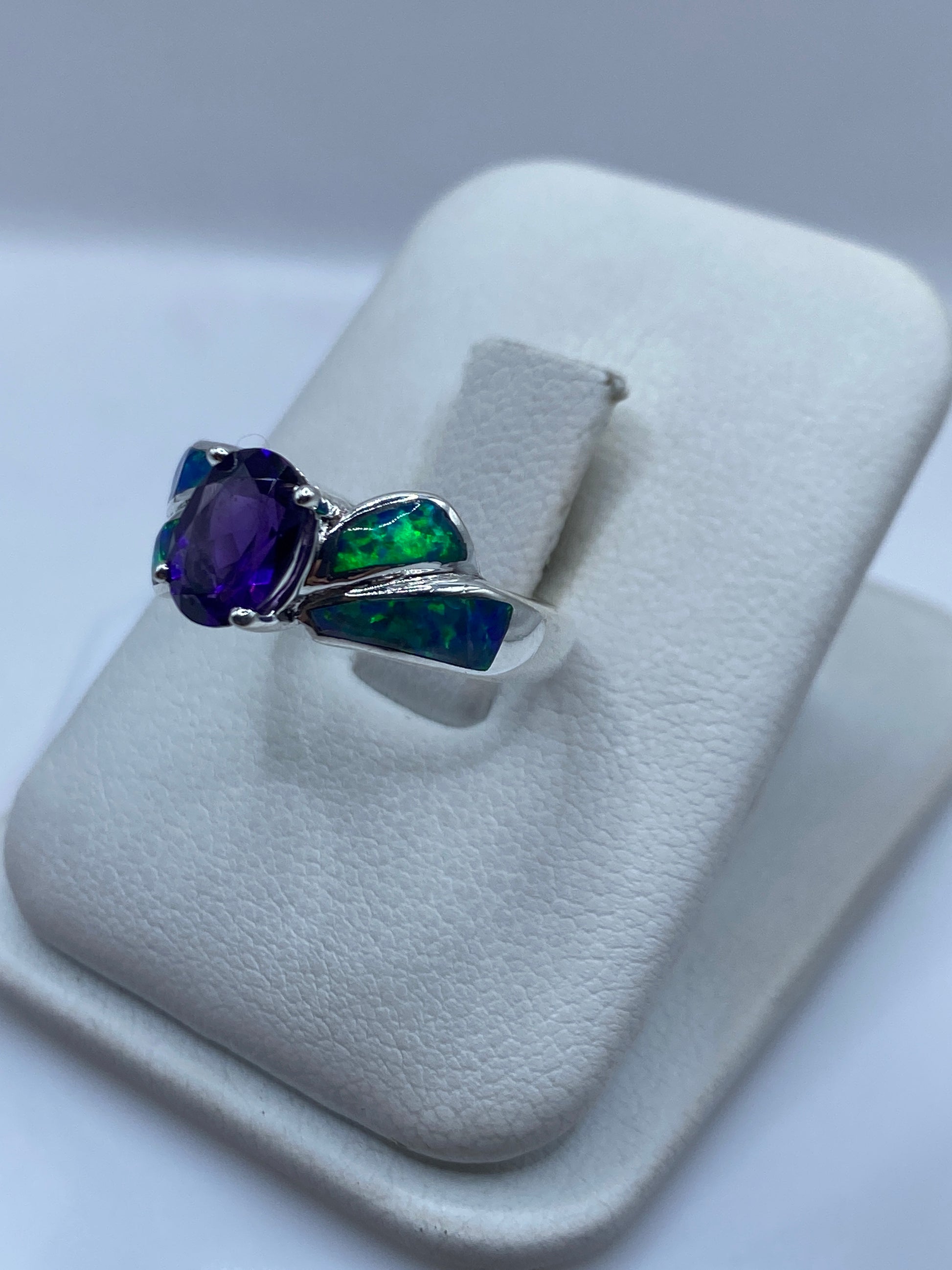 Vista lateral del anillo ópalo fuego destacando el diseño alado en plata pulida