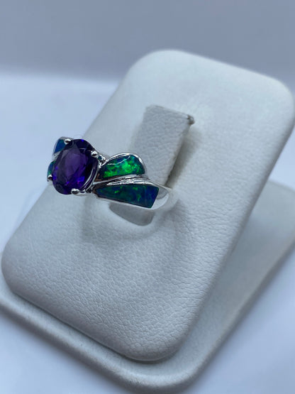 Vista lateral del anillo ópalo fuego destacando el diseño alado en plata pulida