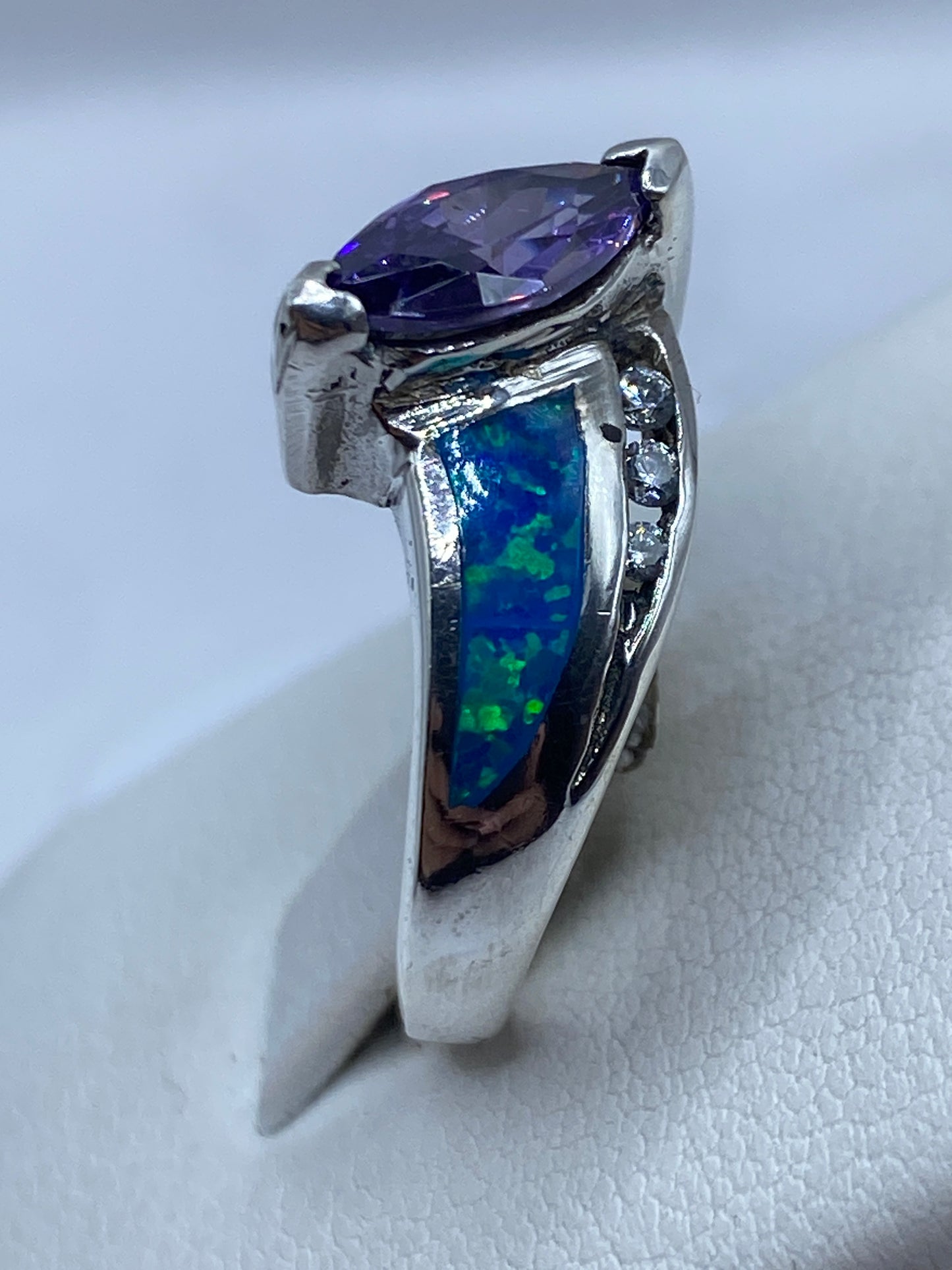 Vista lateral del anillo coctel con ópalo de fuego y bandas torneadas en plata