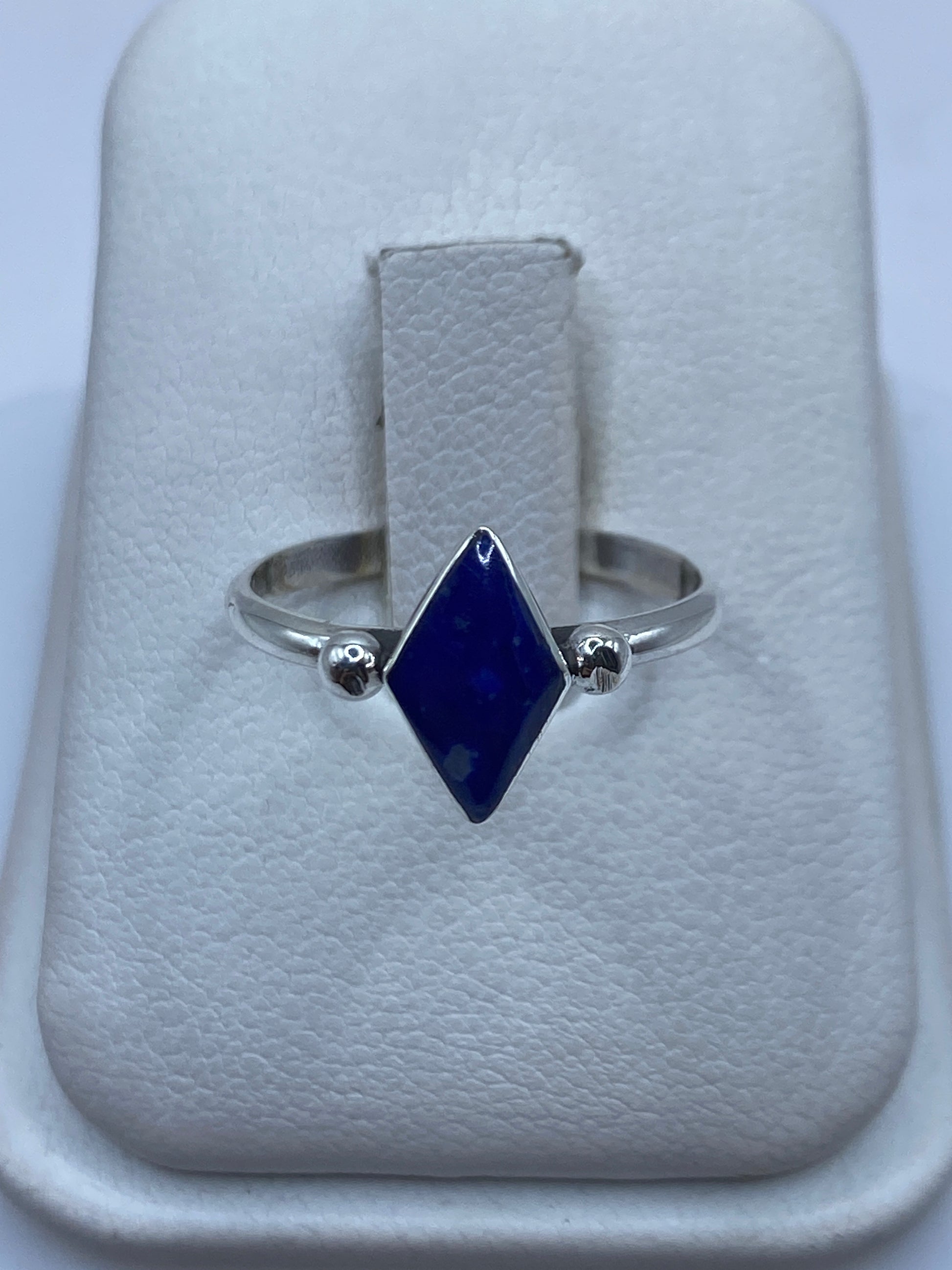 Anillo solitario de plata .950 con piedra azul engastada en el dedo anular
