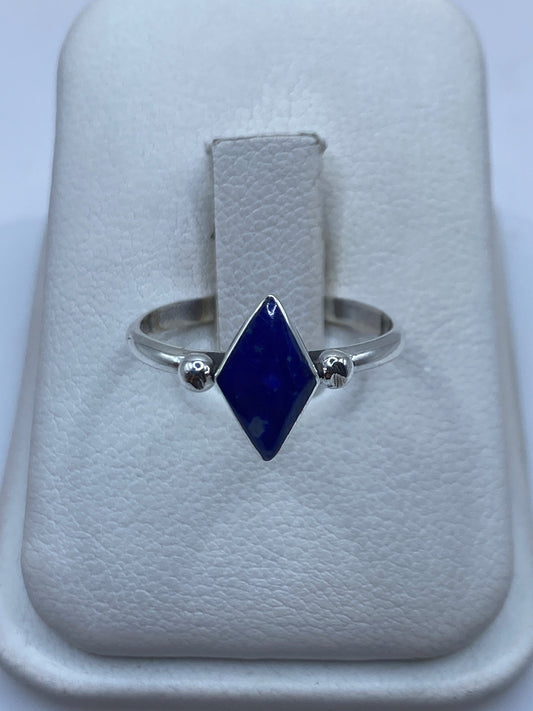 Anillo solitario de plata .950 con piedra azul engastada en el dedo anular