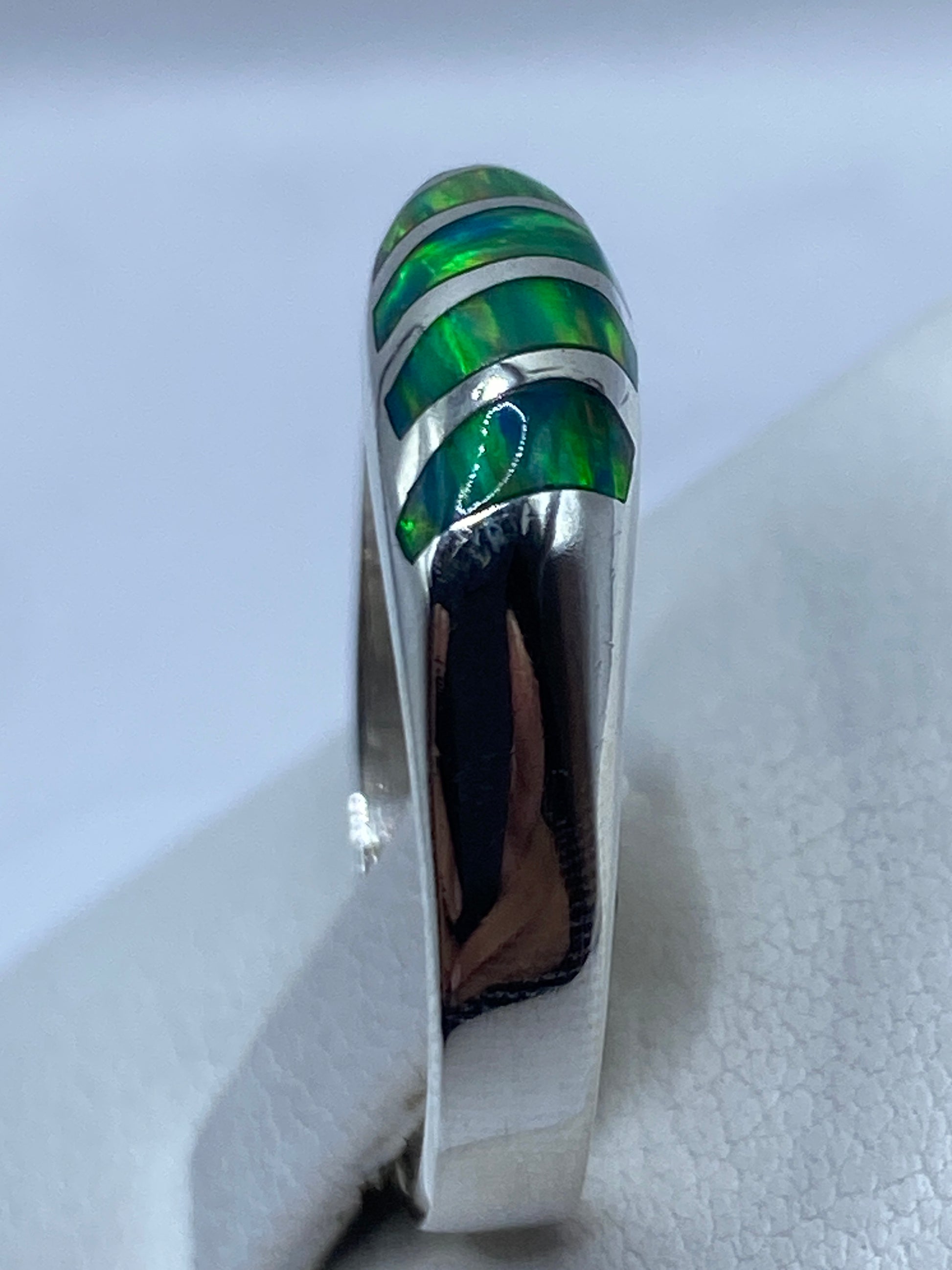 Anillo puesto en dedo, mostrando el esplendor iridiscente del ópalo de fuego