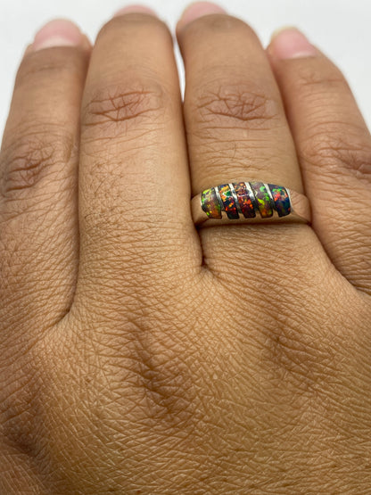 Anillo en dedo mostrando el sello 925 y el brillo del ópalo multicolor