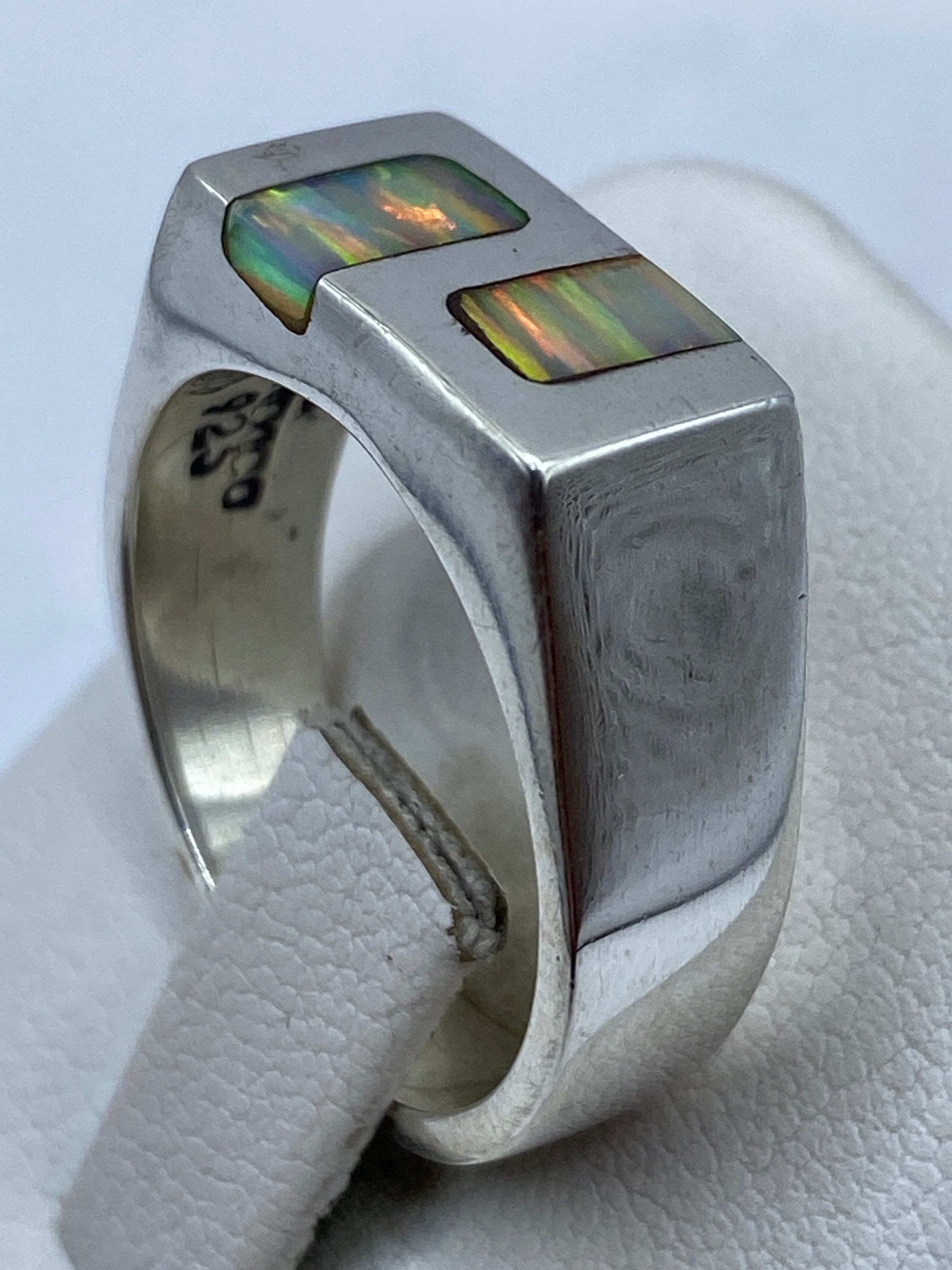 Anillo arquitectónico de plata maciza con ópalo de fuego en la mano de un hombre