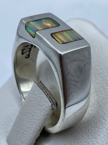 Anillo arquitectónico de plata maciza con ópalo de fuego en la mano de un hombre