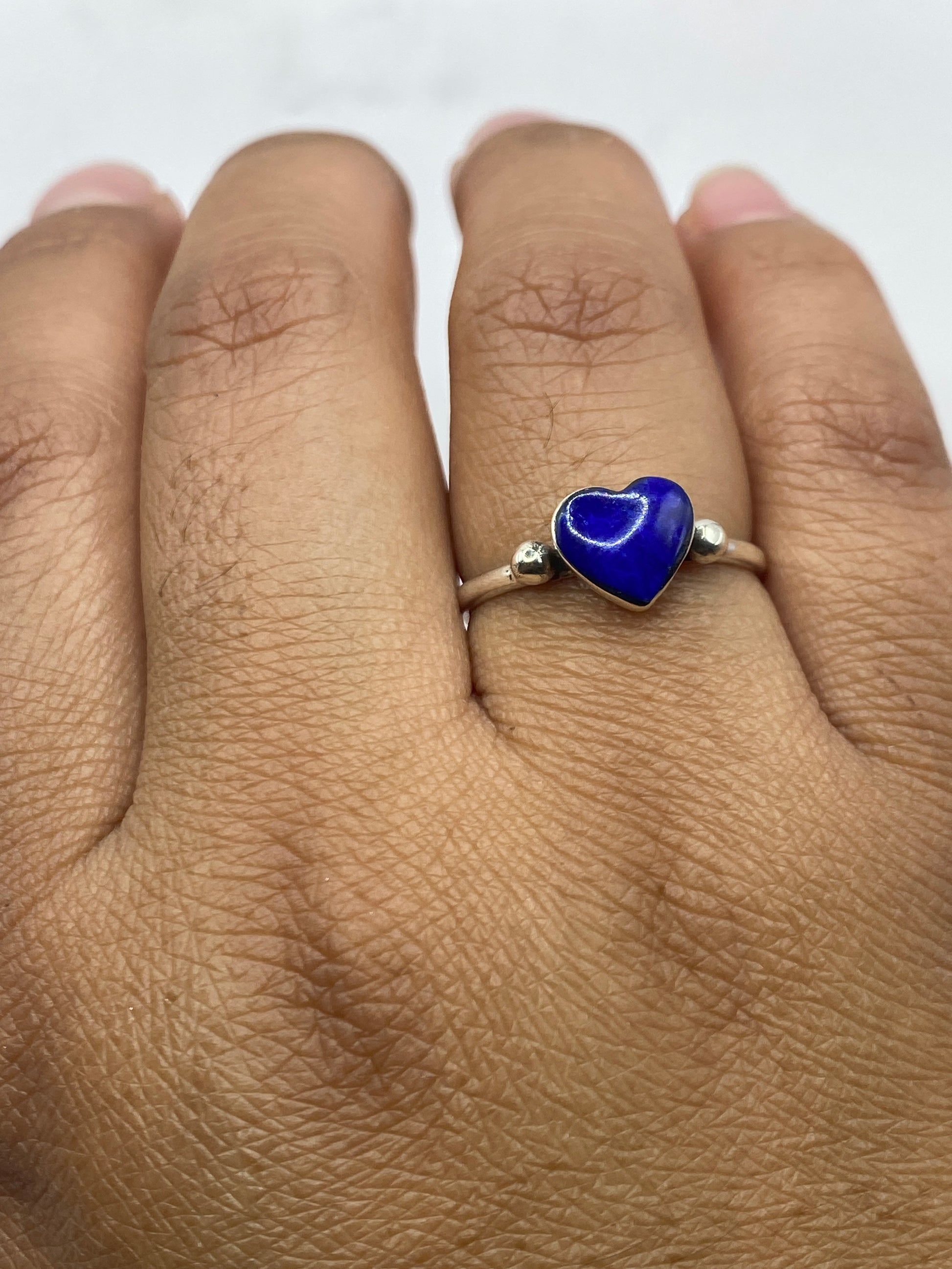 Anillo puesto en dedo mostrando el brillo de la plata .950 y el color azul