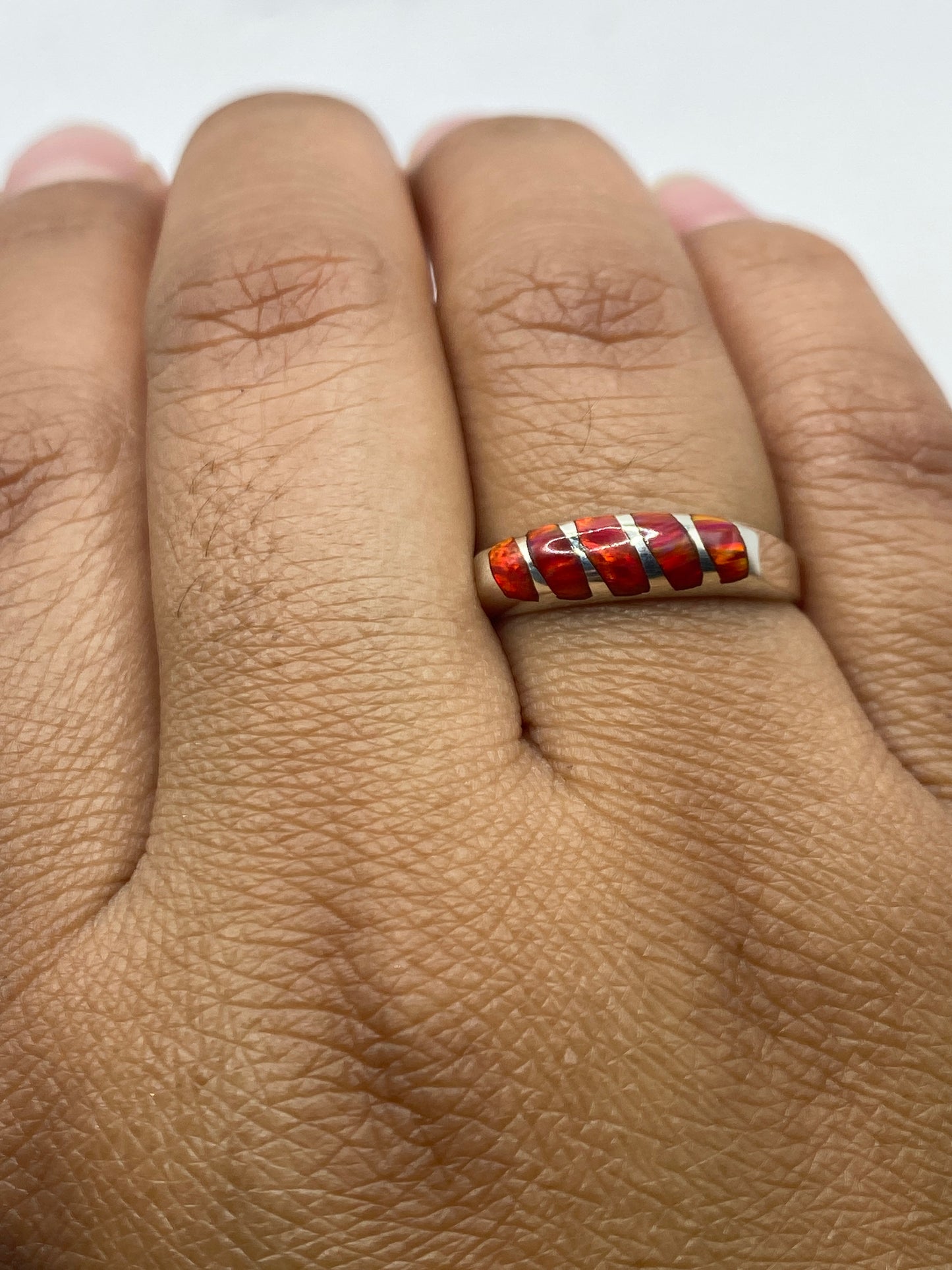 Anillo en la mano mostrando la banda de plata .950 y el engaste de la piedra