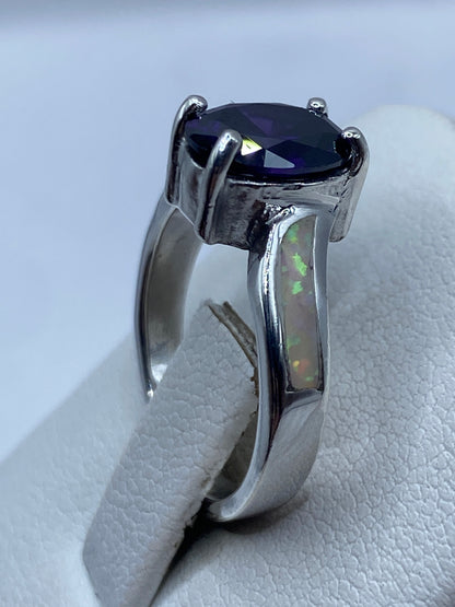 Anillo solitario en plata brillante mostrando el juego de colores del ópalo