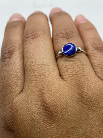 Anillo minimalista en la mano, lapislázuli azul profundo, luz natural