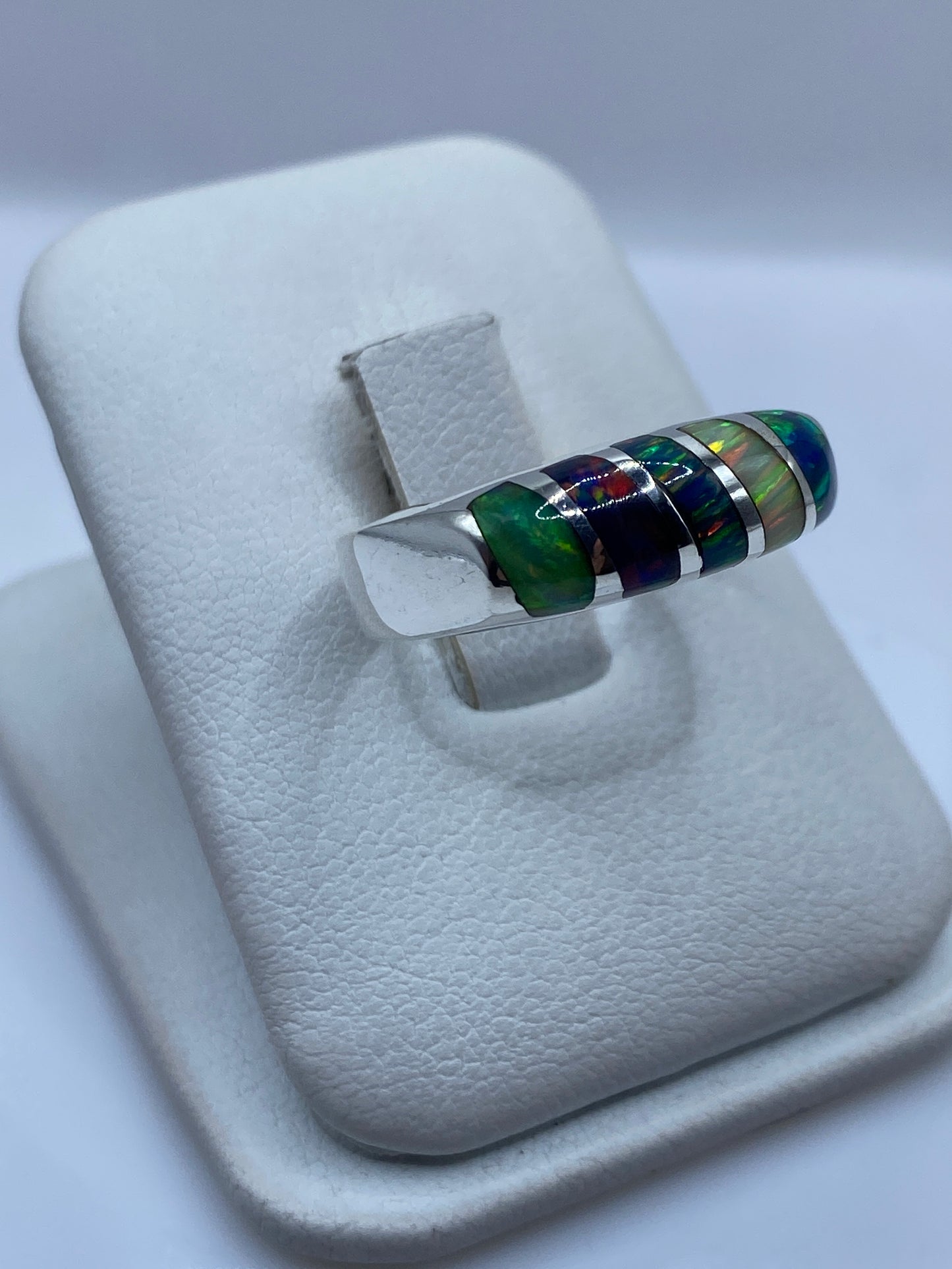 Vista lateral del anillo unisex mostrando el ópalo con fuego rojo, verde y azul
