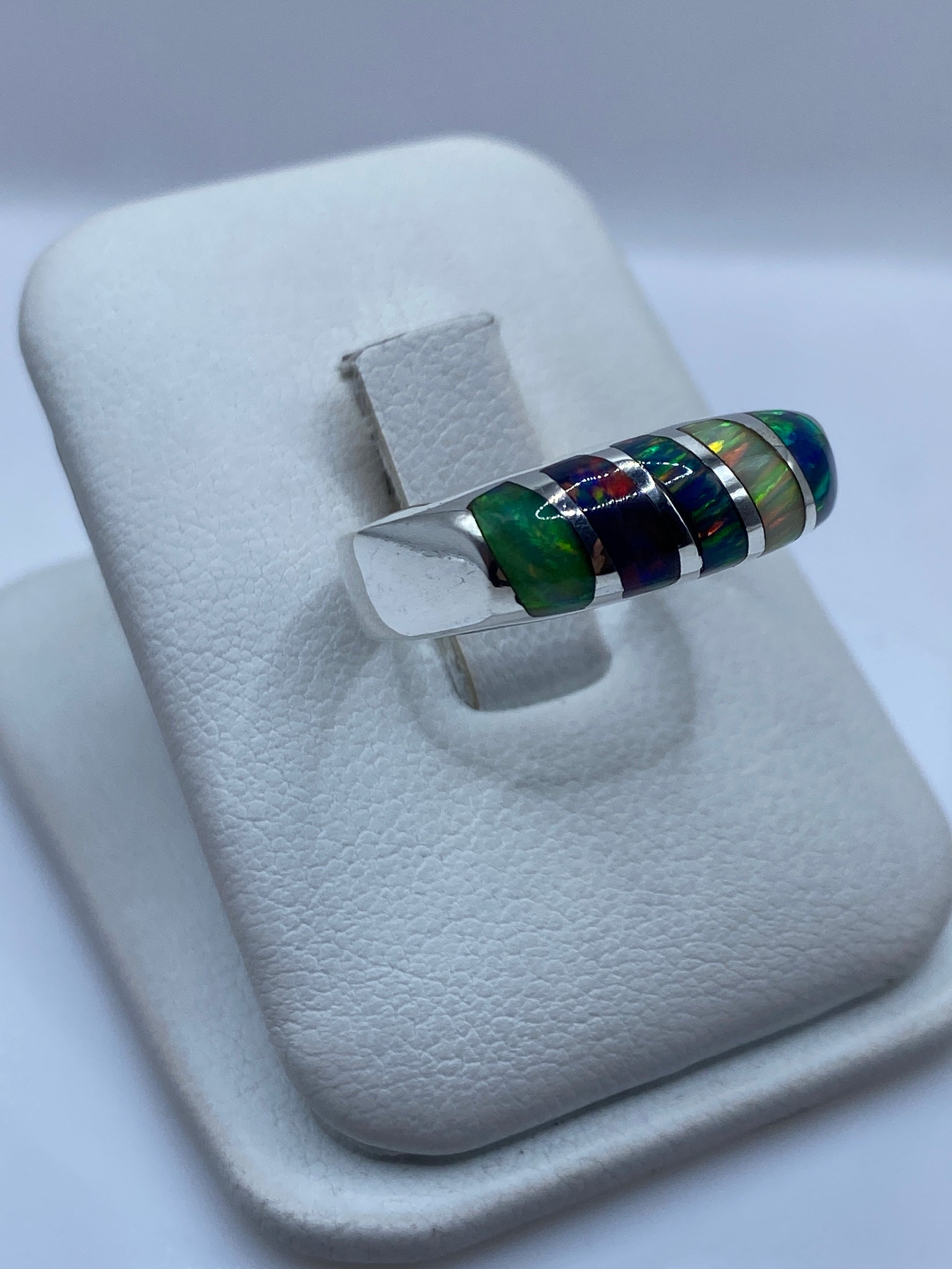 Vista lateral del anillo unisex mostrando el ópalo con fuego rojo, verde y azul