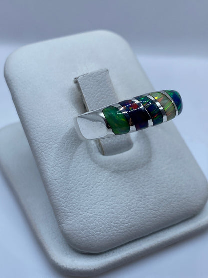 Vista lateral del anillo unisex mostrando el ópalo con fuego rojo, verde y azul
