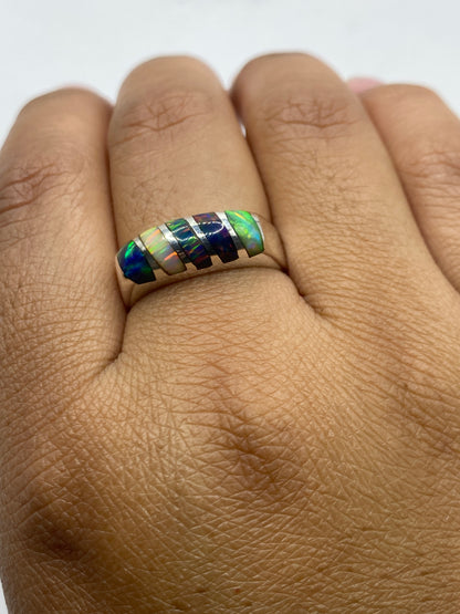 Anillo en la mano mostrando el juego de colores multicolor del ópalo con la luz