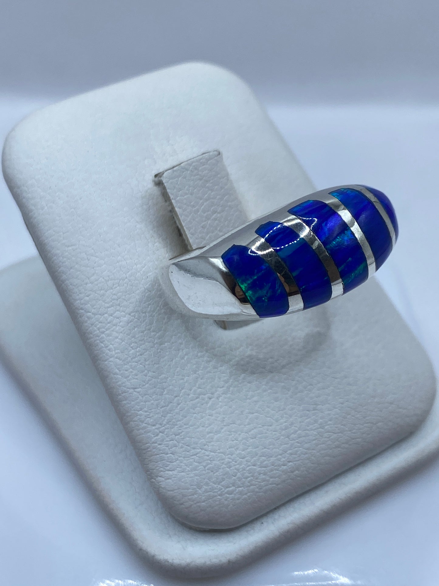 Vista frontal del anillo unisex mostrando el engaste de ópalo azul con juego cromático