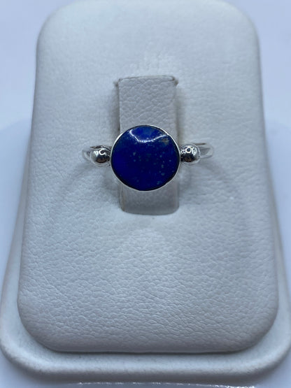 Anillo de plata solitario con lapislázuli azul profundo en mano de mujer