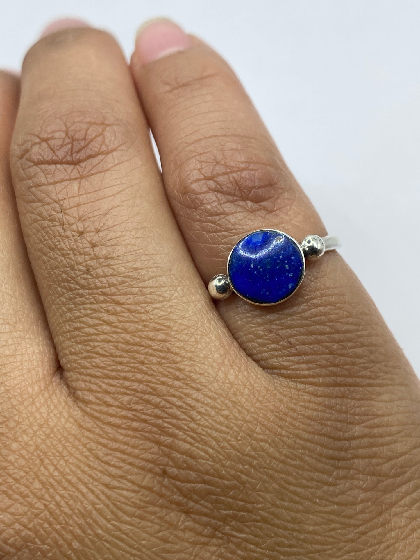 Anillo solitario sobre fondo gris mostrando el sello .925