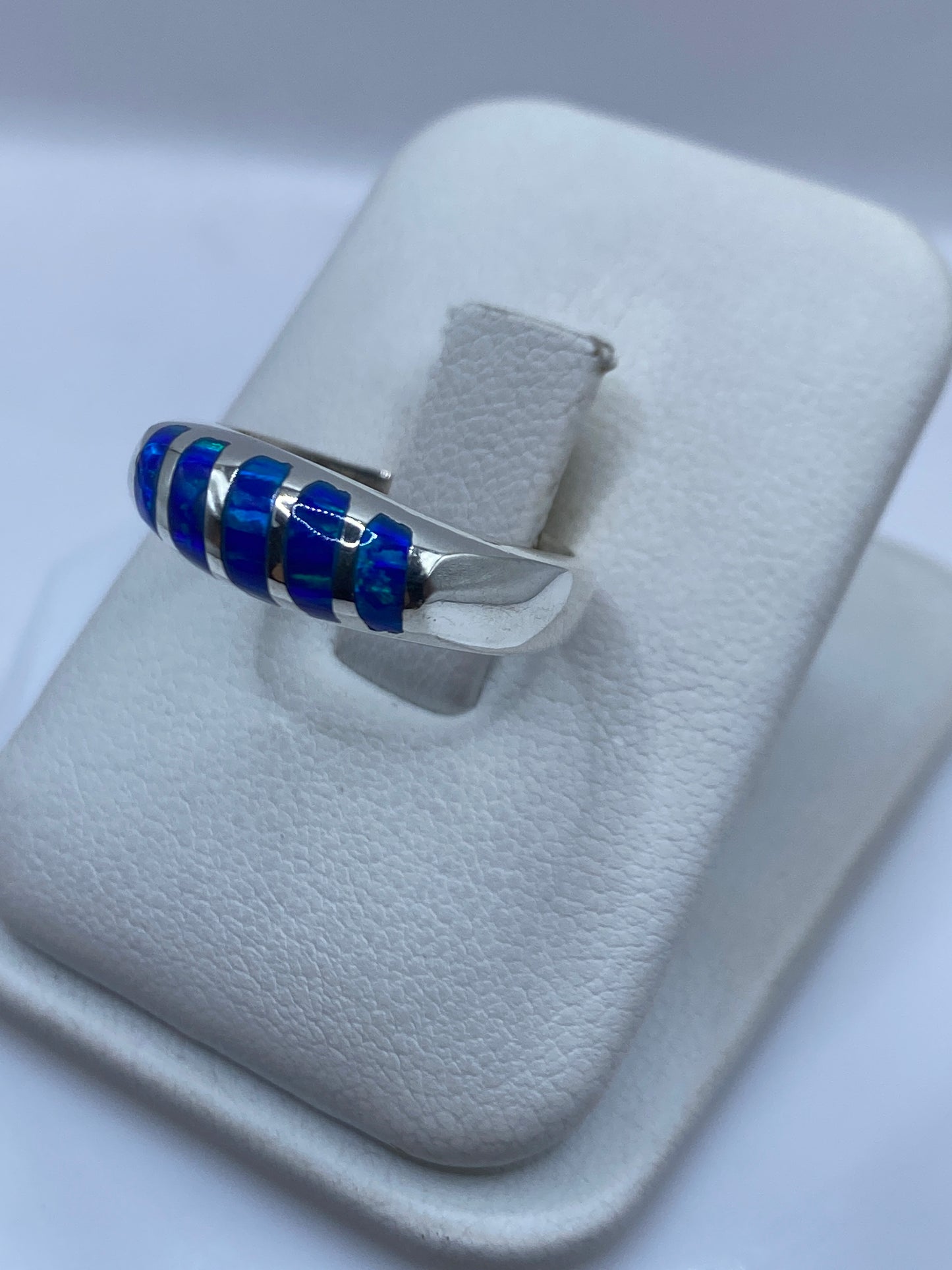 Vista lateral del anillo unisex mostrando el juego de color azul y verde del Ópalo
