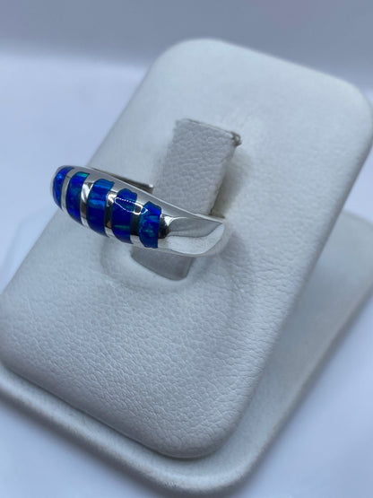 Vista lateral del anillo unisex mostrando el juego de color azul y verde del Ópalo