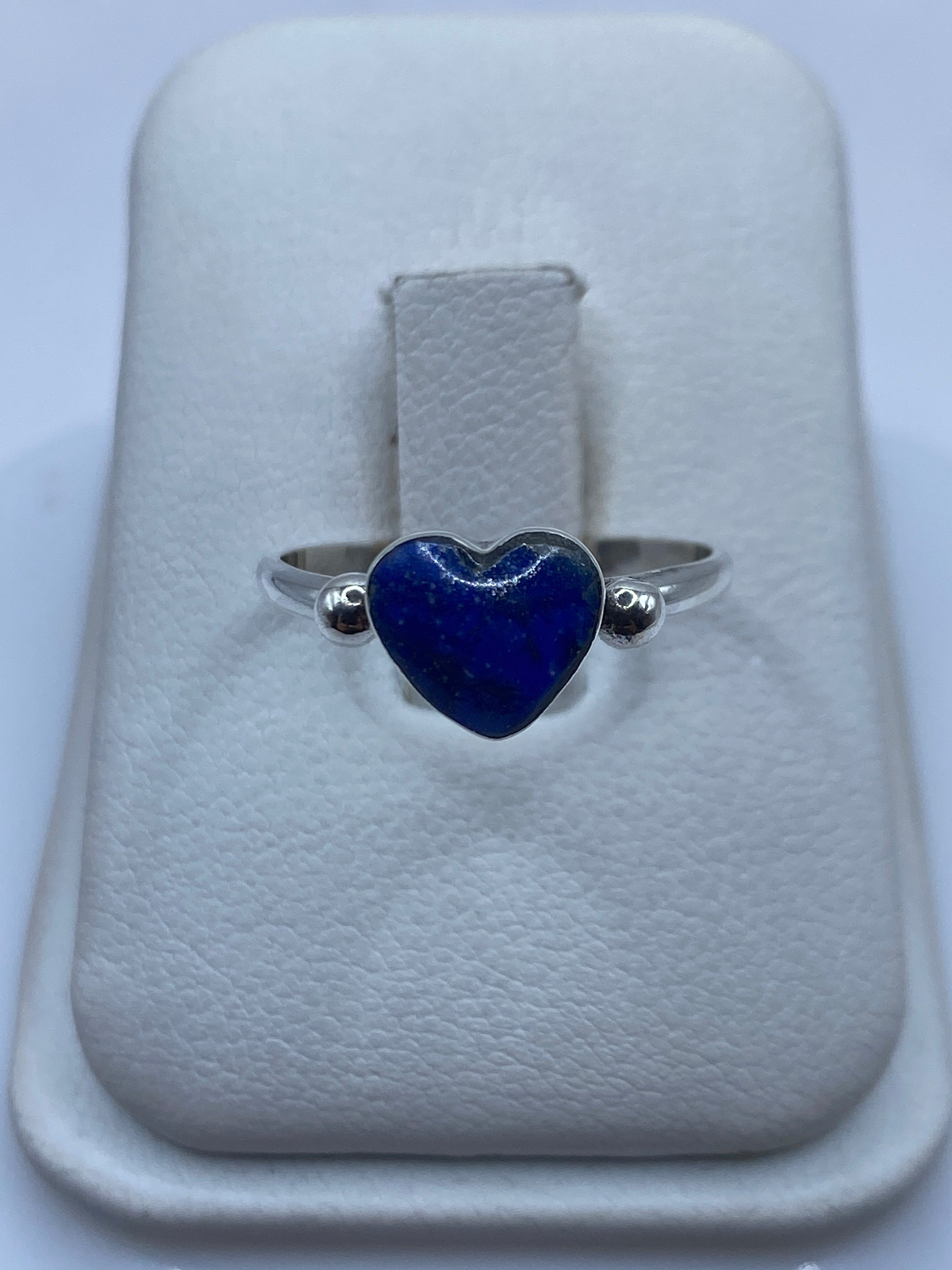 Anillo de plata .950 con corazón de lapislázuli azul profundo en mano de mujer