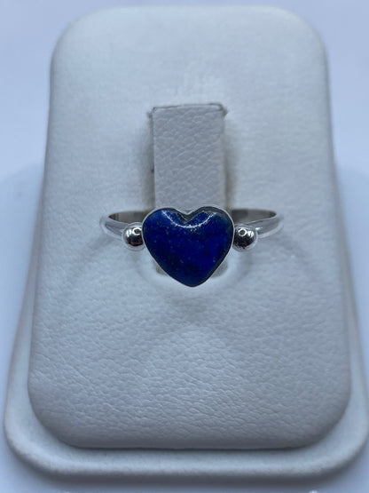 Anillo de plata .950 con corazón de lapislázuli azul profundo en mano de mujer