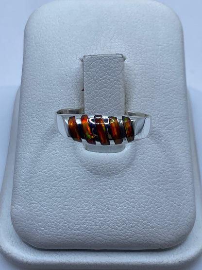 Anillo de plata solitario con ópalo de fuego natural mostrando fuego multicolor en la mano