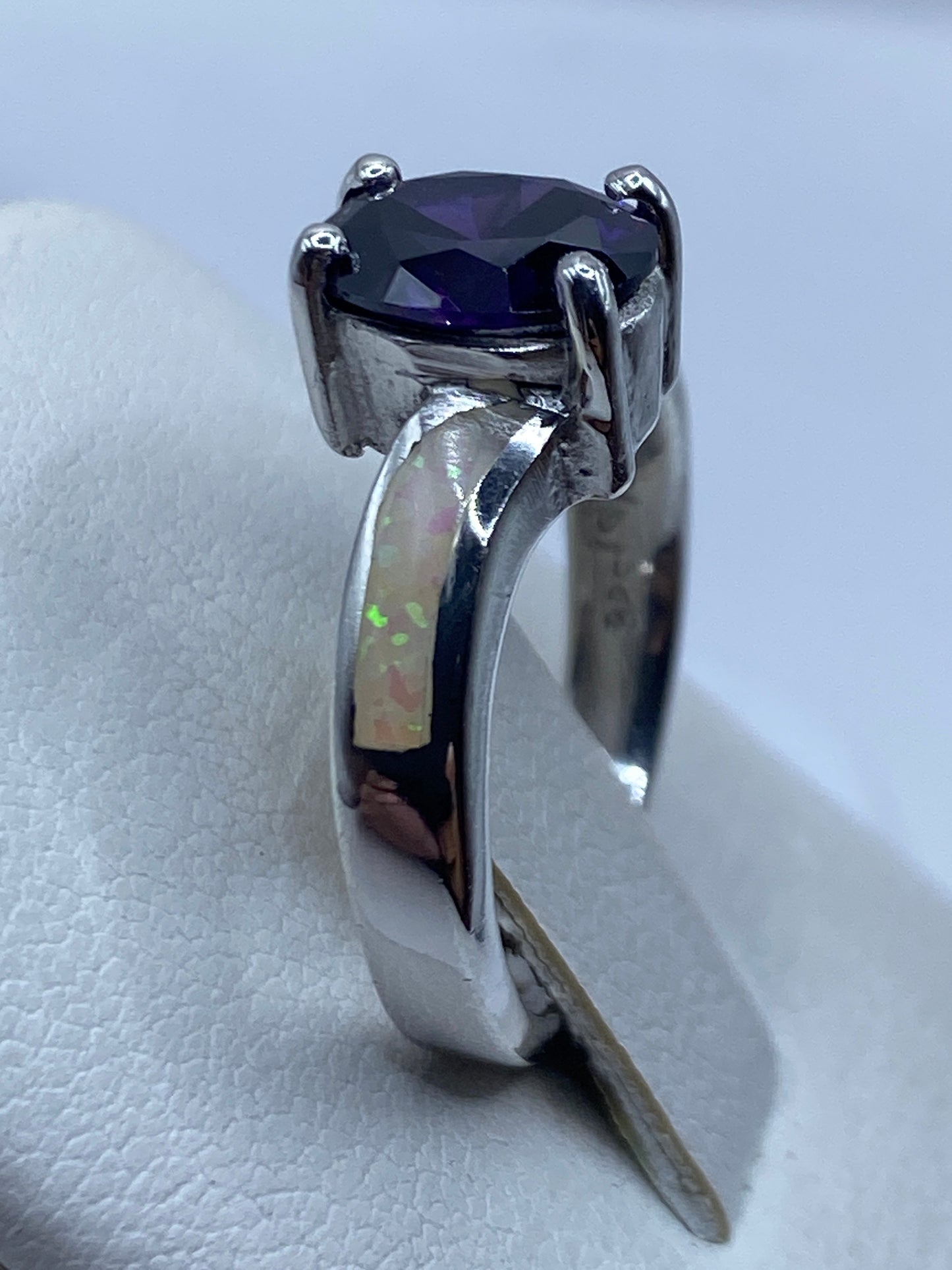 Anillo en la mano de una mujer mostrando el juego de colores único del ópalo