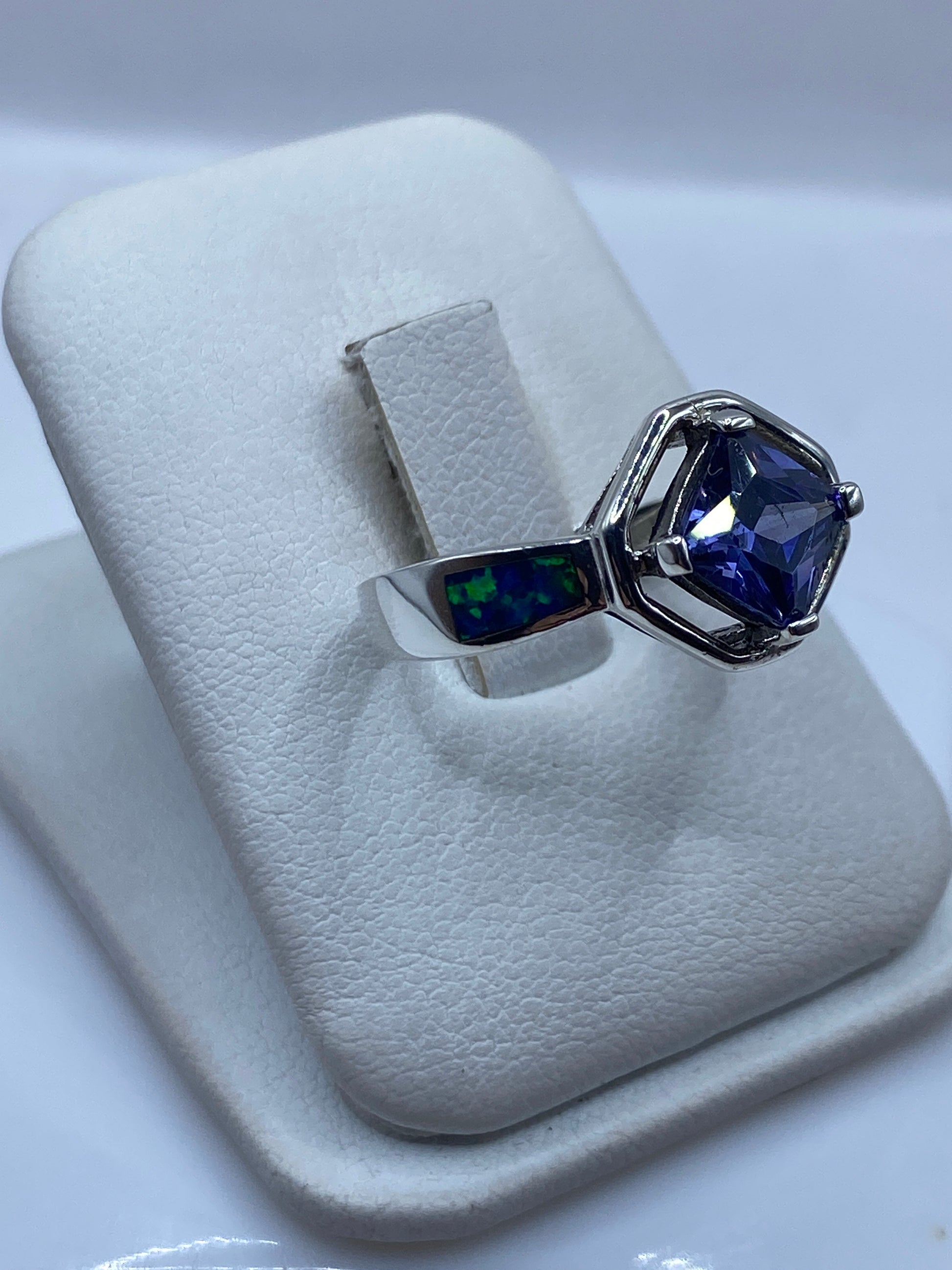 Detalle lateral del anillo mostrando el engaste moderno y las incrustaciones de ópalo a los lados